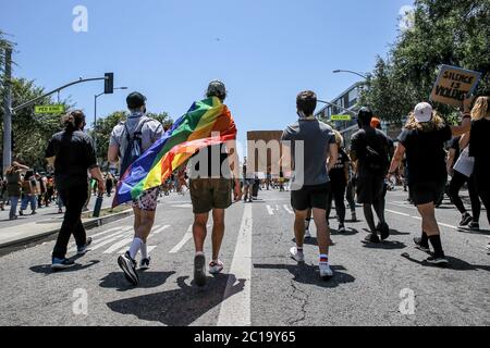 Los Angeles, United States. 14th June, 2020. Protesters march down Santa Monica Boulevard during the demonstration. Thousands of protesters met on Sunday to march in Hollywood and West Hollywood in an anti-racism solidarity march. The day originally was meant to hold the LA Pride Parade but the Pride Parade had been previously canceled due to COVID-19 pandemic. Organizers said earlier this month they would hold a march in solidarity with Black Lives Matter and against police brutality and oppression. Credit: SOPA Images Limited/Alamy Live News Stock Photo