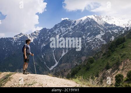 Young tourist in mountains with a walking pole Stock Photo