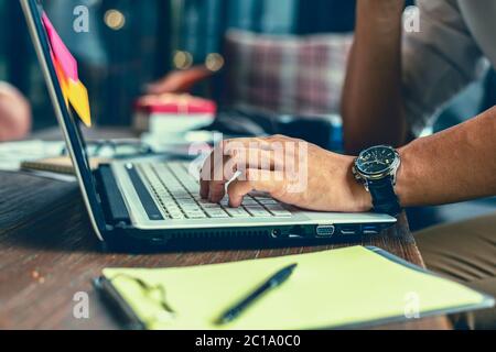 Working with laptop, hands typing on laptop keyboard at the office. Stock Photo