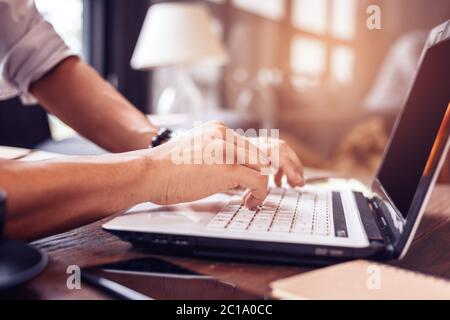 Working with laptop, hands typing on laptop keyboard at the office. Stock Photo