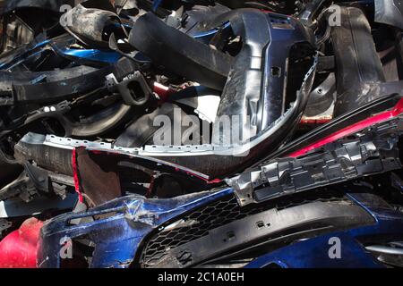 Closeup view on broken plastic and metal cars parts - automobile garbage dump, broken cars waiting for transportation or just thrown out on scrap heap Stock Photo