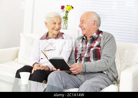 Senior reads stories from a book to his happy wife