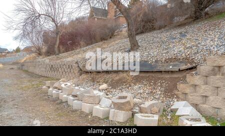 Panorama Neighborhood scenery with view of collapsed retaining wall made of stone blocks Stock Photo