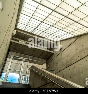 Square Indoor staircase of commercial building that leads to the balcony glass door Stock Photo