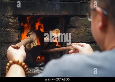 (200615) -- NANCHANG, June 15, 2020 (Xinhua) -- Craftsman Wu Yingshan fires leaf cups with traditional methods at his studio in Ji'an County, east China's Jiangxi Province, June 10, 2020. There are no two identical leaf cups, just as there are no two identical leaves in the world. The making of a leaf cup, a traditional craft endemic in today's Ji'an County, is special -- the artisan has to integrate a leaf into the porcelain ware being worked on. Wu Yingshan, an inheritor of the leaf cup making techniques, started to study on porcelain in 2003. With the development of bulk production, the Stock Photo