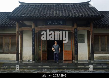 (200615) -- NANCHANG, June 15, 2020 (Xinhua) -- Craftsman Wu Yingshan walks out of his studio in Ji'an County, east China's Jiangxi Province, June 10, 2020.  There are no two identical leaf cups, just as there are no two identical leaves in the world. The making of a leaf cup, a traditional craft endemic in today's Ji'an County, is special -- the artisan has to integrate a leaf into the porcelain ware being worked on.    Wu Yingshan, an inheritor of the leaf cup making techniques, started to study on porcelain in 2003. With the development of bulk production, the traditional ways to make leaf Stock Photo