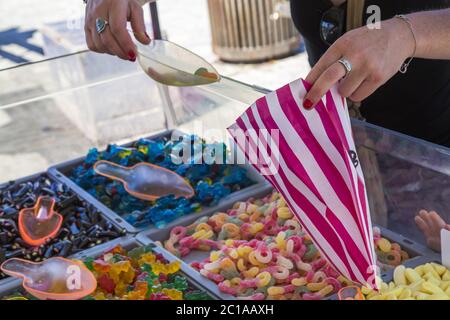 Woman picking gummy sweets in market Stock Photo