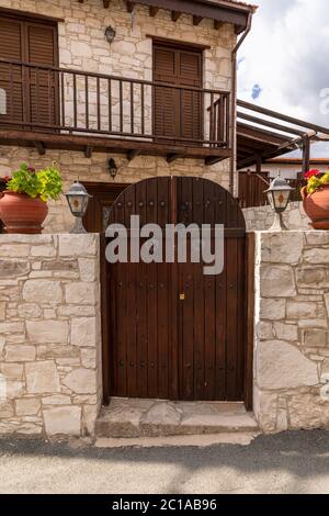 Wooden gate and stone fence in front of house in Cyprus Stock Photo