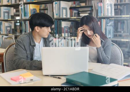 High school or college students  group catching up workbook and learning tutoring on desk and reading, doing homework, lesson practice preparing exam. Stock Photo