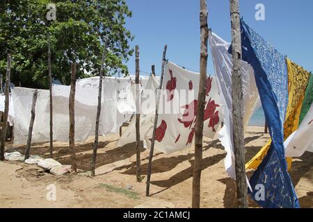 Tablecloths for sale hanging for sale on beach, Ampangorinana Village, Nosy Komba Island, Madagascar. Stock Photo