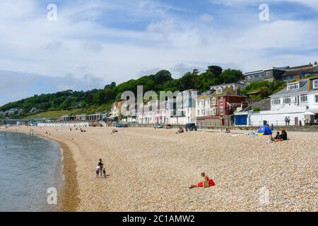 Lyme Regis, Dorset, UK.  15th June 2020.  UK Weather. Visitors and families on the beach enjoying the warm sunshine at the seaside resort of Lyme Regis in Dorset.  Picture Credit: Graham Hunt/Alamy Live News Stock Photo