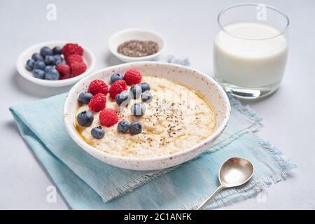 Oatmeal with berries, chia, maple syrup and glass of milk Stock Photo