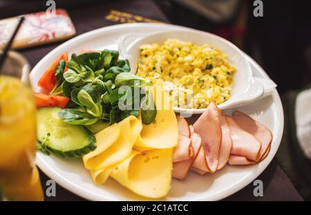 Healthy breakfast. Scramble with fresh vegetables, tomatoes, cucumber ham cheese Stock Photo