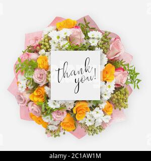 Fresh flowers bunch and card with words thank you written on it Stock Photo