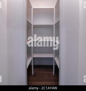 Square Interior of a walk in closet with shelving units and clothes ...