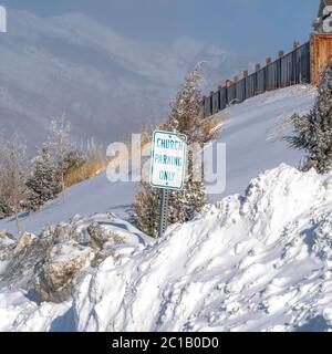 Square Building and Church Parking Only sign on the snowed in slope of Wasatch Mountain Stock Photo