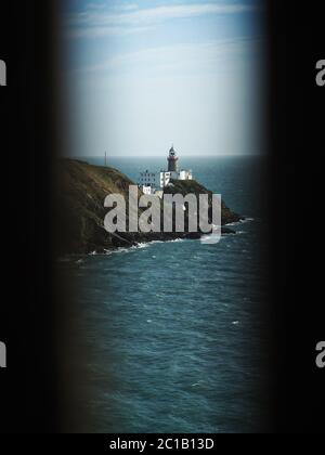 Baily lighthouse through fence in Ireland near Dublin, Sea Stock Photo