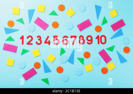 Children's educational game with numbers and colorful plastic figures on a blue background. Stock Photo