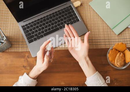 Top view close up of unrecognizable woman using hand sanitizer while working at home office, copy space Stock Photo