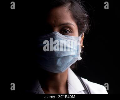 Close up of professional Medical doctor or nurse protective medical facial mask in dark room - Concept of covid-19 pandemic hope concept. Stock Photo