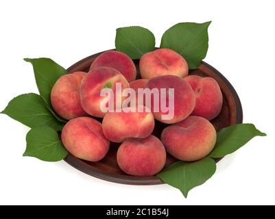 Peaches with leaves in a plate isolated on white Stock Photo
