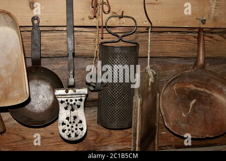 old mountain country life kitchen utensils hanging on wall Stock Photo