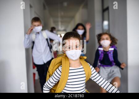 Group of cheerful children going home from school after covid-19 quarantine and lockdown.