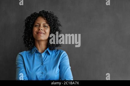 Smiling businesswoman standing by an office chalkboard Stock Photo