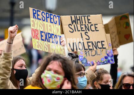 Richmond, North Yorkshire, UK - June 14, 2020: Protesters wear PPE face masks and hold homemade anti racism signs high at a Black Lives Matter protest Stock Photo