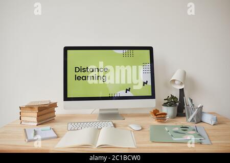 Background image of minimal workplace setting with computer on desk and digital learning website on screen, copy space Stock Photo