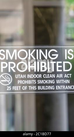 Vertical frame Smoking is Prohibited sign close up on clear glass door of building in Utah Stock Photo