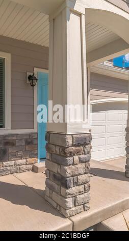 Vertical Arched entrance at the porch of home with blue front door beside window Stock Photo