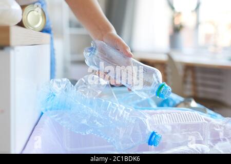 Close-up of female hand sorting plastic bottles she throwing bottles into the other bin Stock Photo