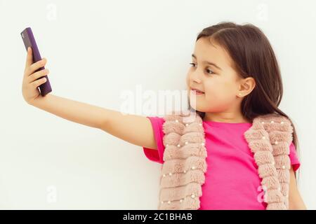 Portrait of little girl taking a selfie isolated over white background Stock Photo