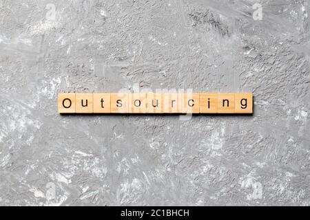 outsourcing word written on wood block. outsourcing text on table, concept. Stock Photo