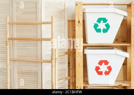 Image of two white plastic garbage bins on the wooden table in workshop Stock Photo