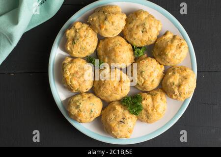 Savory muffins on a plate. Top view background of cheese  and herb muffins isolated on rustic black Stock Photo