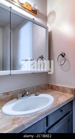 Vertical crop Oval sink on marble countertop with cabinet inside bathroom of home Stock Photo