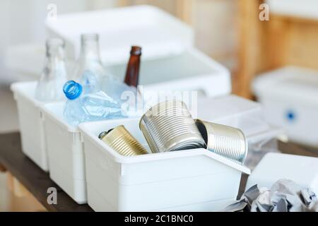 Close-up of cans in the container and other sorted waste on the table Stock Photo