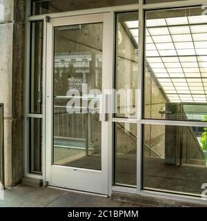 Square crop Glass door and wall with view of slanted frosted roof over stairway of building Stock Photo