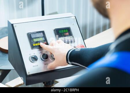 a close-up of the operator the man presses the button on the control panel with the control devices on the furniture production. Stock Photo