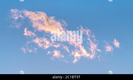 Panorama crop Wispy white clouds tinged pink at sunset Stock Photo