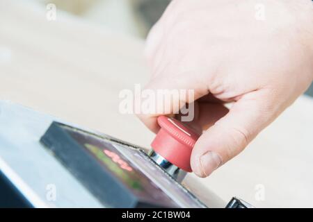 Close-up of a man's hand on a red button on the control panel. Emergency stop or start of equipment and production Stock Photo