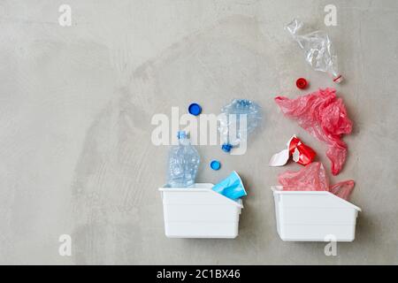 High angle view of two plastic containers with plastic bottles and packages isolated on grey background Stock Photo