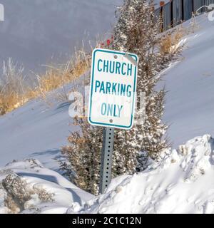 Square frame Building and Church Parking Only sign on the snowed in slope of Wasatch Mountain Stock Photo