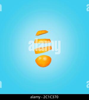 Creative concept with flying orange. Sliced orange isolated on blue background. Yeast fruits floating in the air. Stock Photo