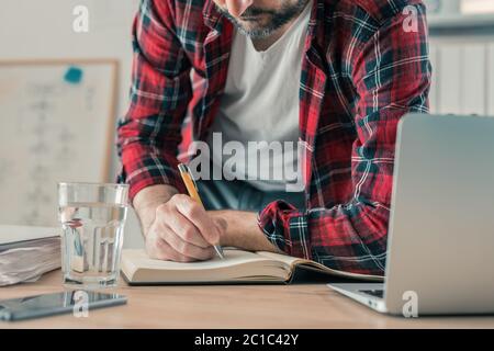 Freelancer writing notes in notebook, selective focus Stock Photo