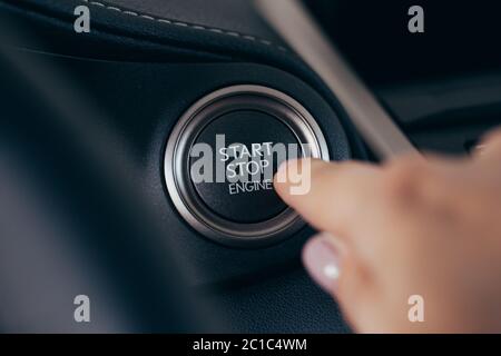 Car start stop system with finger pressing the button, horizontal image Stock Photo
