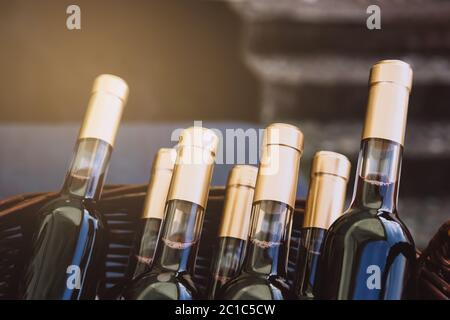 Bottles of red wine in basket. Wine bottles before sale. Copy space for text. Stock Photo