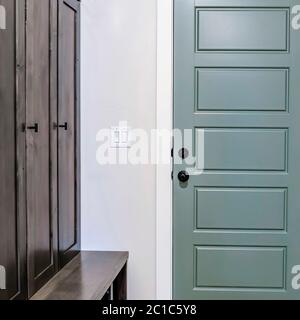 Square frame Hallway with runner rug on the floor that leads to the fire door of a home Stock Photo